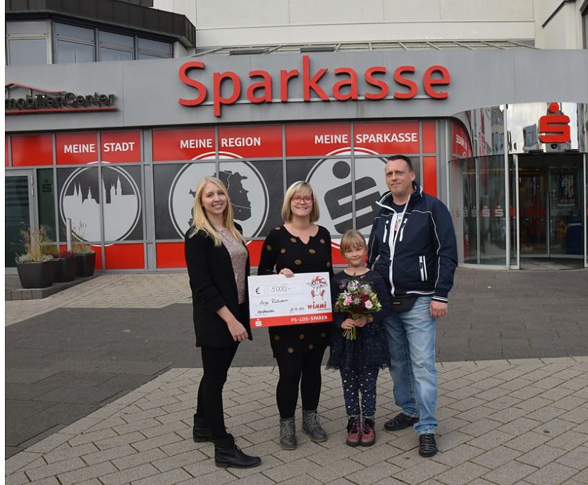 Kundenberaterin Lena Muth &uuml;berreicht der gl&uuml;cklichen Gewinnerin einen symbolischen Scheck und Blumen. (Foto: Kreissparkasse Nordhausen)