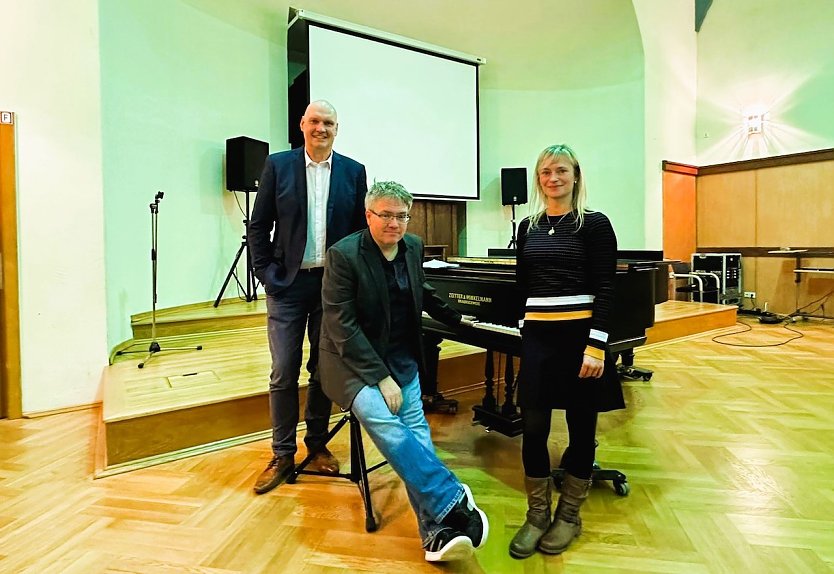 B&uuml;rgermeister Steffen Grimm (links) und Bibliotheksleiterin Janett Noack (rechts) pr&auml;sentierten anl&auml;sslich des 100. Geburtstages der Stadtbibliothek Musikkabarettist Matthias Reuter (Mitte). (Foto: Janine Skara)