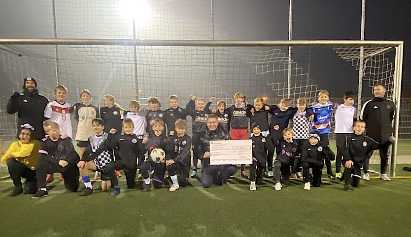 Toni Hyseni (vorne in der Mitte mit Scheck) &uuml;berreicht den Fu&szlig;ballern 1.000 Euro (Foto: FSV Preu&szlig;en)