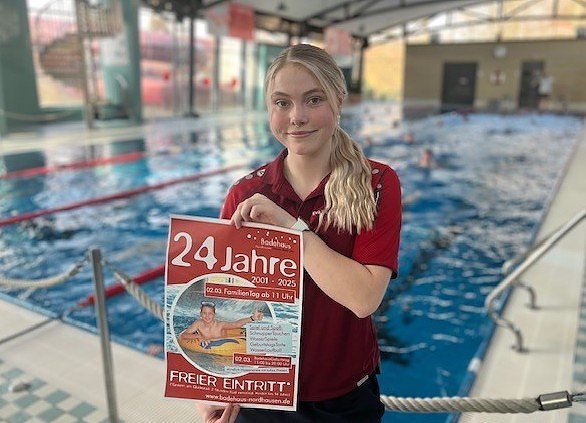 Eva, Auszubildende im Badehaus, pr&auml;sentiert stolz das Geburtstagsplakat; zur Er&ouml;ffnung war sie noch nicht geboren (Foto: Badehaus Nordhausen)