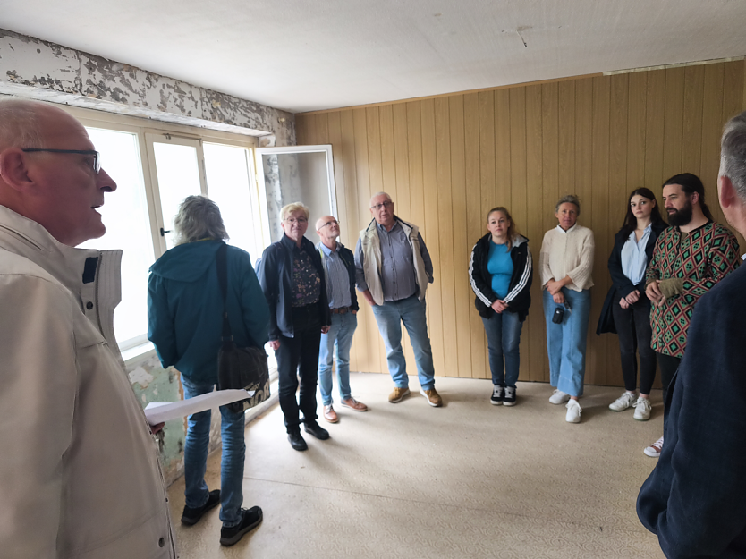 Martin Hauck (li.) erkl&auml;rt, worauf es in diesem Teil des unsanierten Geb&auml;udes ankommt und was zur Landesgartenschau 2026 geplant ist. (Foto: Ilka K&uuml;hn)