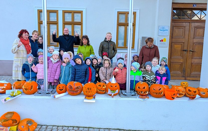 Die Kinder der Kita Schlossparkspatzen k&uuml;rten zusammen mit B&uuml;rgermeister Steffen Grimm, ihren Erzieherinnen und Mitarbeitern der Stadtverwaltung die Gewinner des diesj&auml;hrigen K&uuml;rbiswettbewerbs. (Foto: Janine Skara)