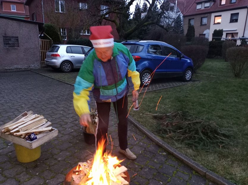 Volker Wente mit Nikolaus-Zipfelm&uuml;tze f&uuml;ttert die Flammen mit kleinen Fichtenzweigen. (Foto: Kurt Frank)