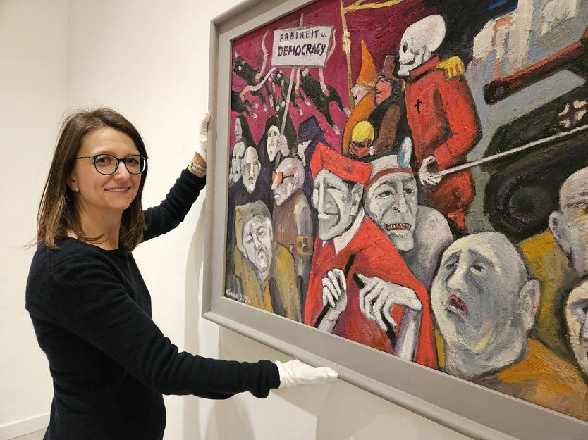 Die Kuratorin Dr. Nora Hilgert mit dem Gem&auml;lde Der anachronistische Zug oder �Freiheit und Democracy�  (Foto: Matthias Nolte, M&uuml;hlh&auml;user Museen)